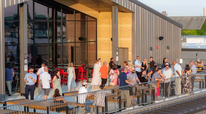 Guests mingling on the roof deck in warm afternoon light